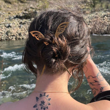 Load image into Gallery viewer, tattooed woman by the rivers edge wearing her hair in a bun with two hair sticksing 